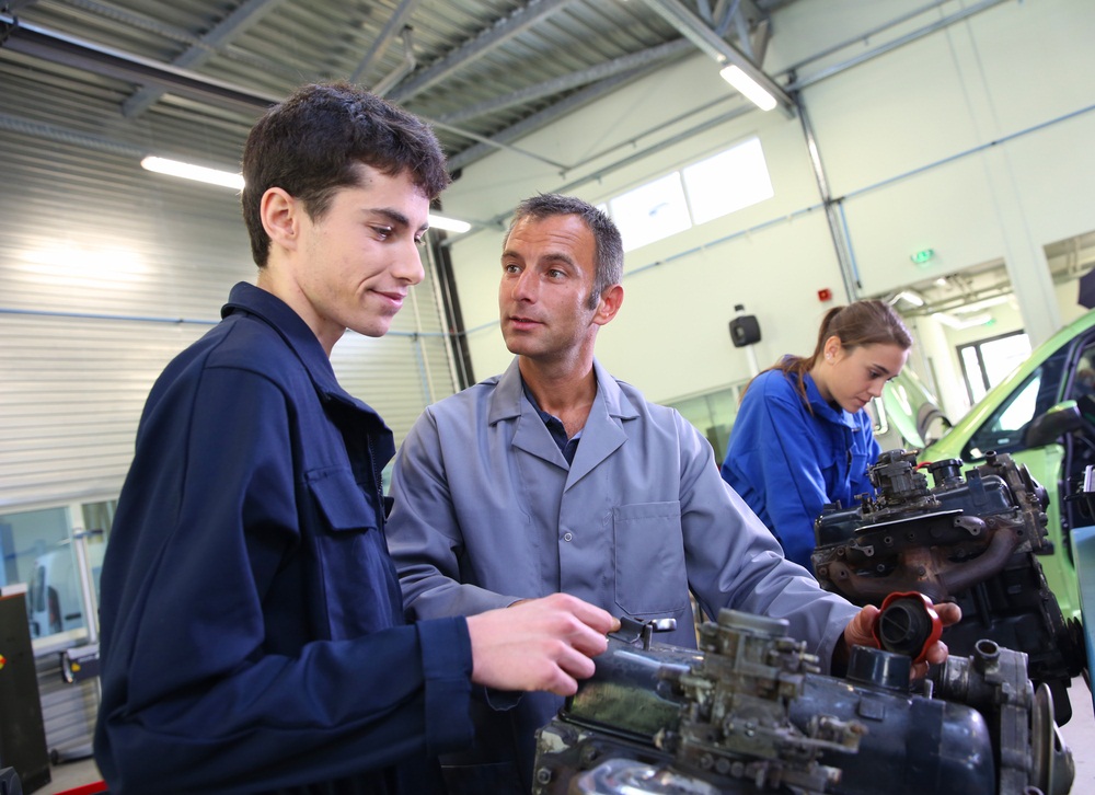 Image of young adult and instructor working in a mechanic shop